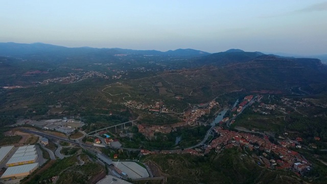 在日落时，空中拍摄的城市由山脉对天空，无人机飞过风景-蒙特塞拉特，西班牙视频素材