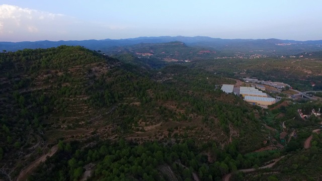 航拍绿色景观与建筑的天空，无人机飞越森林-蒙特塞拉特，西班牙视频素材