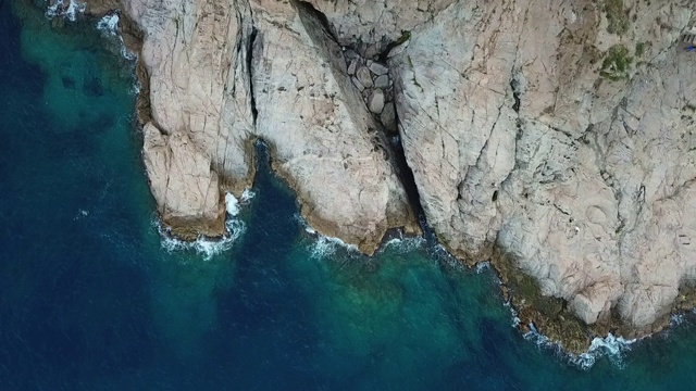 航拍海浪溅在蓝色的海洋岩石形成，无人机上升的海洋- Tossa de Mar，西班牙视频素材