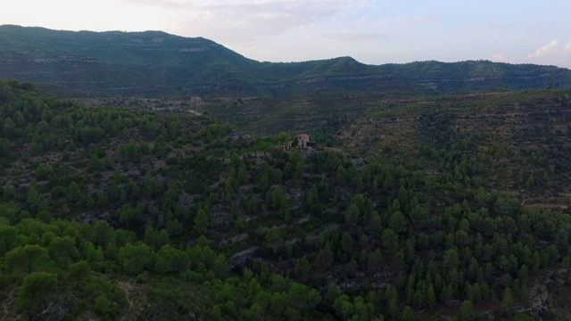 空中拍摄的结构在山上对天空，无人机向前飞行在自然绿色景观-蒙特塞拉特，西班牙视频素材