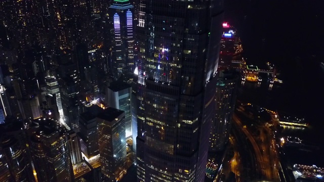 航拍在城市街道上的摩天大楼，无人机在夜间降落-中国香港视频素材