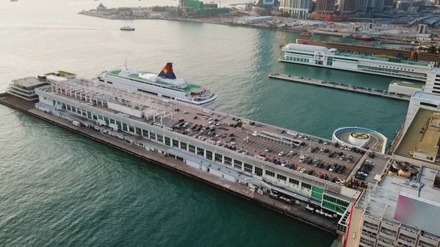 航拍的车辆在建设邮轮停泊在海上，无人机飞过建筑在城市-香港，中国视频素材