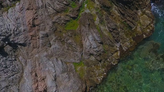 航拍在阳光明媚的一天，无人机在海滩上空-略雷特德马尔，西班牙的岩层视频素材