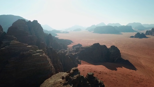 空中拍摄的岩层在沙漠的天空，无人机下降在晴朗的一天自然干旱景观-瓦迪拉姆，约旦视频素材