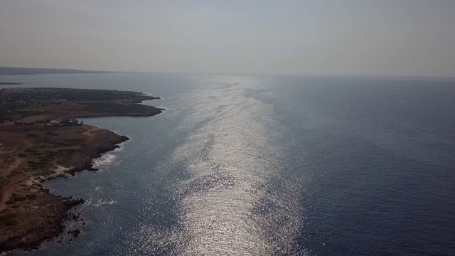 航拍田园诗般的海与岩石海岸在晴朗的一天，无人机下降在海洋对天空-帕福斯，塞浦路斯视频素材