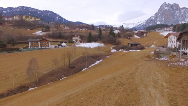 航拍:在冬季，无人机在房屋和村庄附近的雪中扫荡。意大利Dolomites视频素材