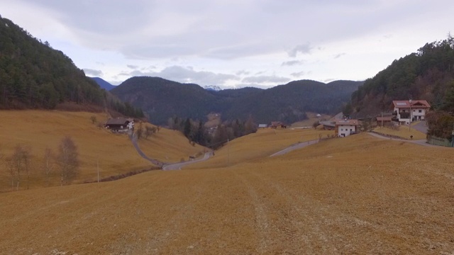 航拍:在意大利白云石山附近的村庄里，一架无人机朝着一辆行驶在路上的汽车飞去视频素材