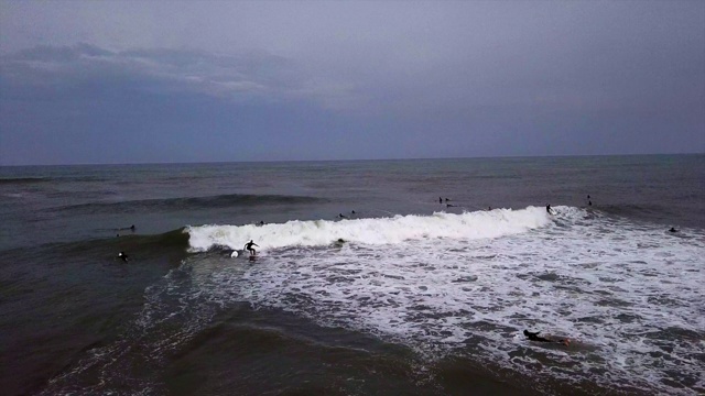 空中拍摄人们在海浪上冲浪对着天空，无人机飞过游客-特拉维夫，以色列视频素材