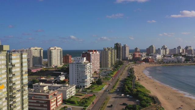 航拍城市建筑的海滩上的天空，无人机向前飞行-埃斯特角，乌拉圭视频素材