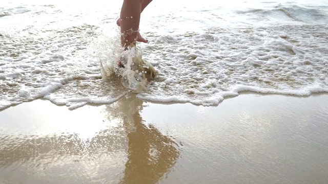 在晴朗的日子里，光着脚的女人走在空旷的海滩上视频素材