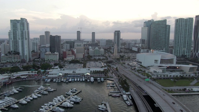 航拍在港口的船在城市的桥对天空，无人机在日落时在海上的桥上向前飞行，航拍在海上的船视频素材