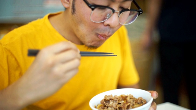 亚洲男人吃牛肉烧牛肉，日本人用碗配烤牛肉视频素材