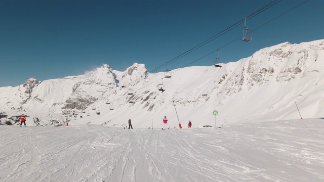 在一个阳光明媚的日子里，在法国阿尔卑斯山下坡滑雪视频素材