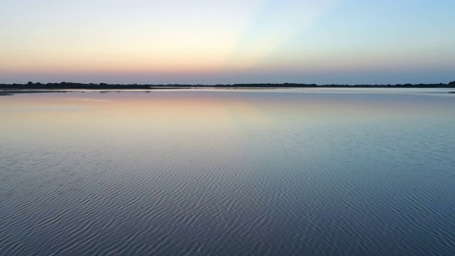 航拍的田园诗般的海洋对天空在日落，无人机是飞向前的海洋- Camargue，法国视频素材