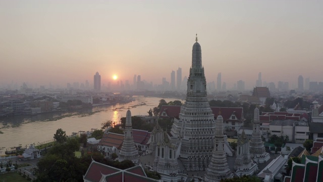 航拍日落时分城市河边的佛教寺庙，无人机从著名的地标上空飞过——泰国曼谷视频素材