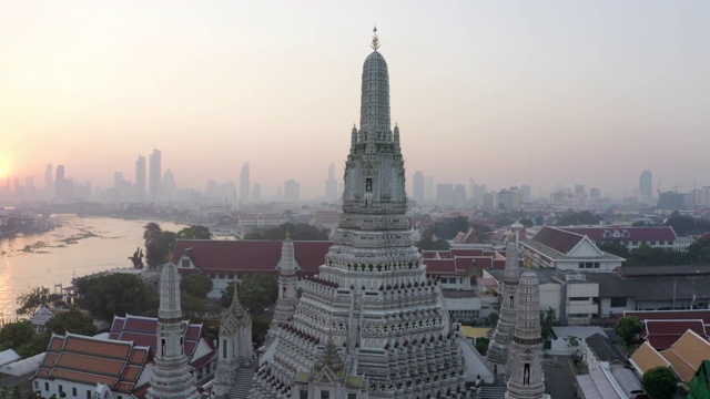 空中平移拍摄的著名佛教寺庙在城市的河流在日落，无人机飞过地标对天空-曼谷，泰国视频素材