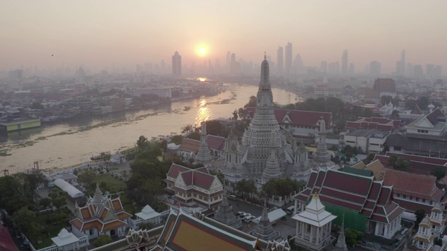 航拍的佛教寺庙在城市的河流在日落，无人机向前飞行的著名地标对天空-曼谷，泰国视频素材