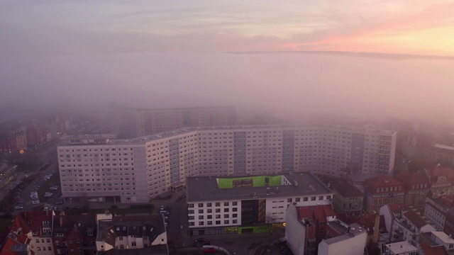 空中拍摄日落时城市中的建筑物和车辆，无人机在雾天飞行-埃尔福特，德国视频素材