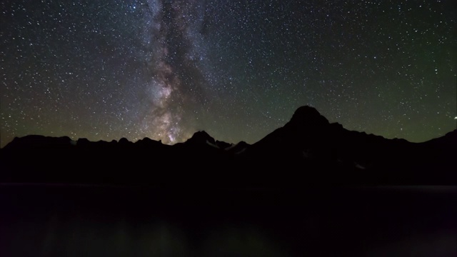 加拿大班夫，夜间在银河湖边拍摄的轮廓山脉视频素材