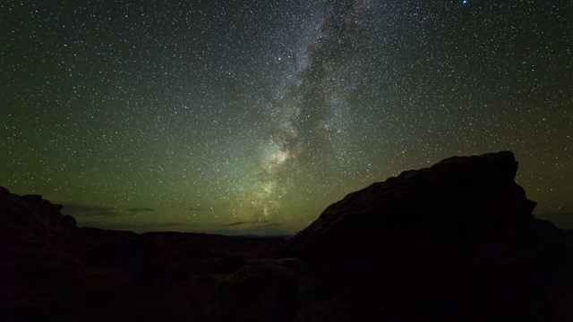 平移时间流逝拍摄的银河在夜晚剪影岩石景观，时间流逝的星星视频素材