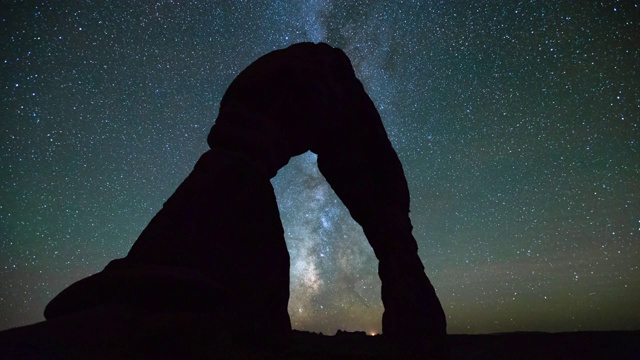 在夜晚的银河映衬下，在沙漠中精致的拱门剪影的延时拍摄-拱门国家公园，犹他州视频素材