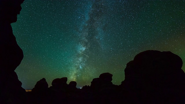 灯光轨迹和银河的时间流逝拍摄在夜空下的沙漠剪影岩石-拱门国家公园，犹他州视频素材