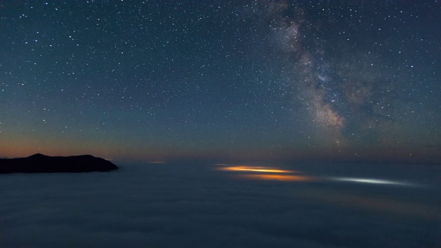 加拿大托菲诺，在夜空中群山映衬下的云朵上拍摄的银河视频素材