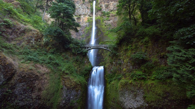 低角度延时拍摄桥在美丽的Multnomah瀑布在森林植物-波特兰，俄勒冈州视频素材