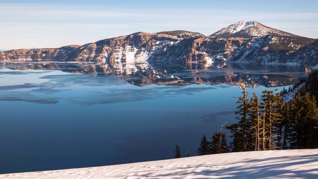 在火山口湖附近的山脉和天空的雪从一天的冰浮动的镜头视频素材