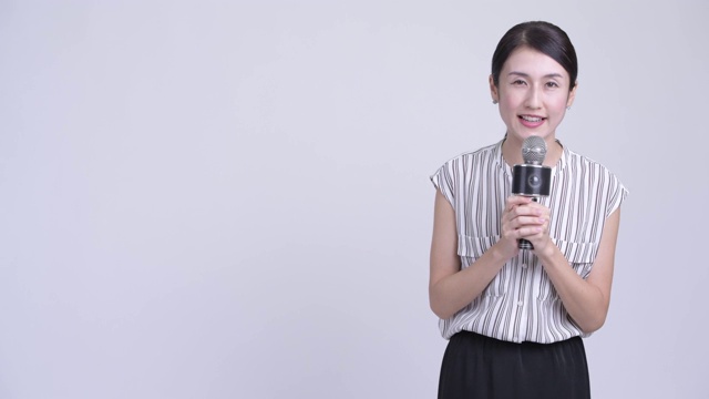 快乐美丽的亚洲女商人作为新闻播音员视频素材