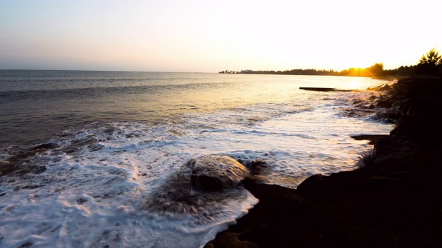 日落时分，夏威夷大岛上，一艘游船在海上对着天空拍摄海浪视频素材