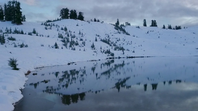 摇摄树和雪反射在湖上的天空在日落-精灵湖，不列颠哥伦比亚省视频素材