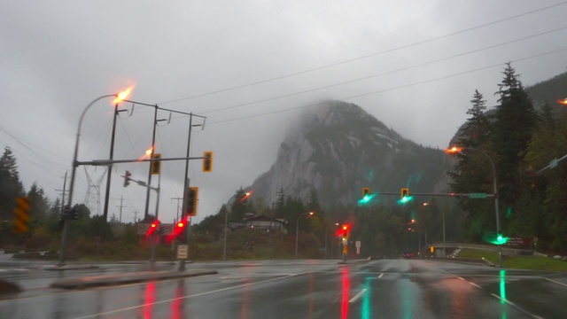 英属哥伦比亚省的精灵湖，雨季在潮湿的高速公路上与天空相映衬的交通信号拍摄的车辆视频素材