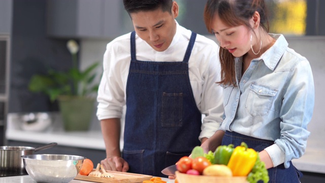 亚洲年轻夫妇在自家厨房做饭视频素材