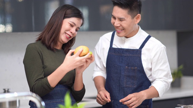 亚洲年轻夫妇在厨房做饭视频素材