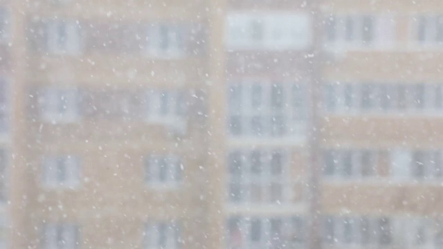 一个城市的降雪。简单的场景——飘落的雪花。视频下载