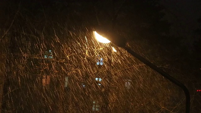 湿雪在街灯下迅速飞舞。春夜的暴风雪。视频素材