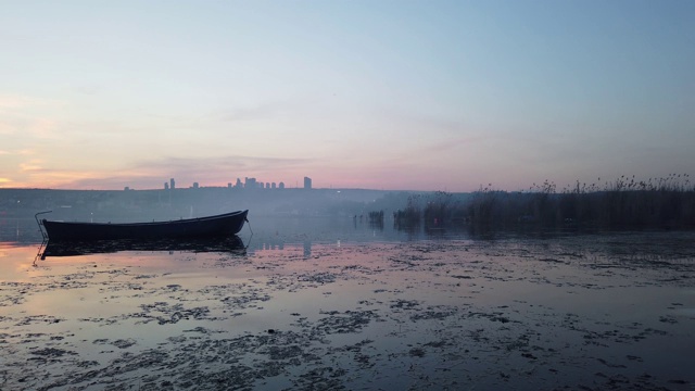 夏日湖岸上的夕阳和古老的木制渔船。城市景观和湖泊，(土耳其安卡拉)视频素材