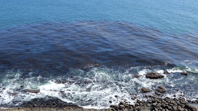 海浪拍打着布满岩石的海岸线缓慢移动视频素材