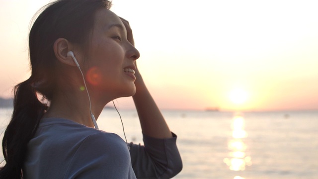 亚洲女人在海滩上使用智能手机视频素材