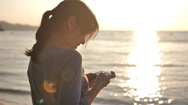 亚洲女人在海滩拍照视频素材