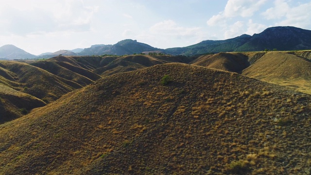 顶视图的山谷与黄色的草在天空的背景。射杀。沙漠景观与干燥的黄草山地地形视频素材