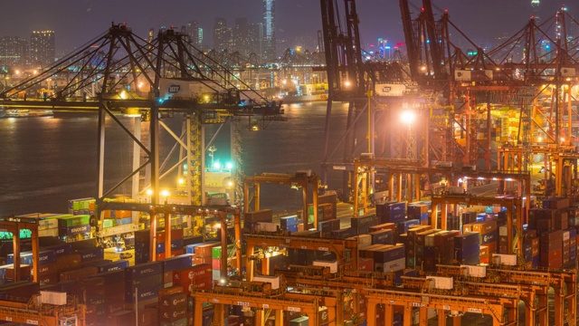 在香港进出口业务物流中，国际港口夜间用起重机装载集装箱的时间间隔视频素材