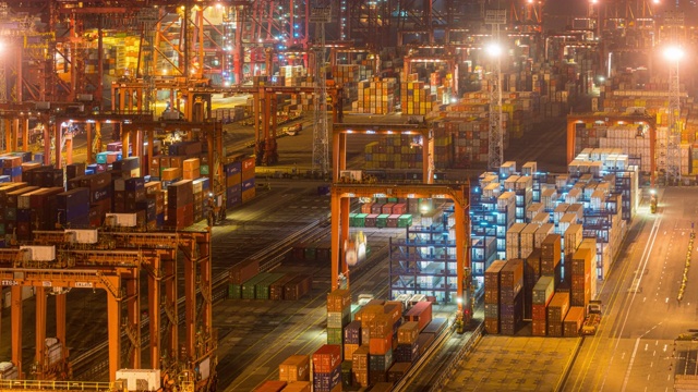 在香港进出口业务物流中，国际港口夜间用起重机装载集装箱的时间间隔视频素材