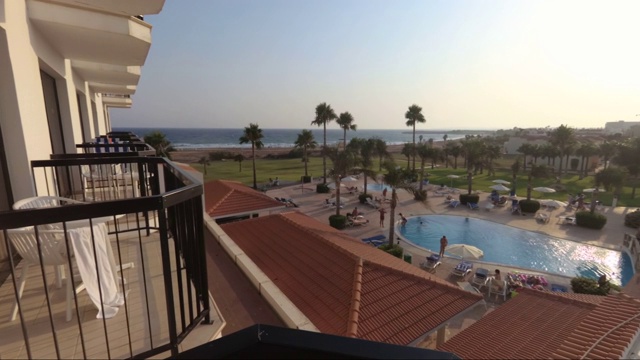 夕阳从酒店拍摄。大海，游泳池，棕榈树，海滩。视频素材