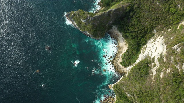 从上面看，令人惊叹的鸟瞰图，岩石海岸沐浴在日落绿松石的海洋。重镇Penida,印度尼西亚。视频素材