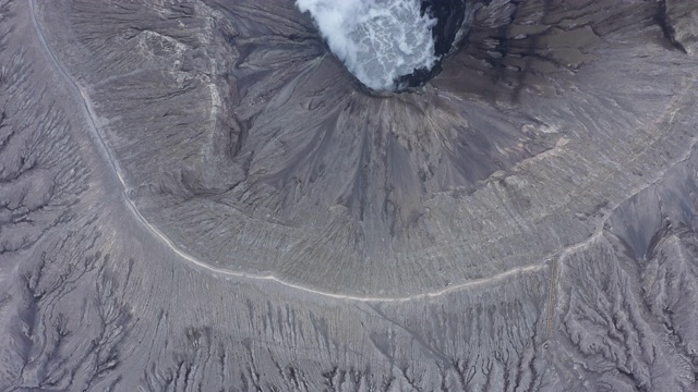 从上面俯瞰，令人惊叹的布罗莫火山鸟瞰图和从火山口升起的气体云。视频素材