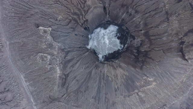 从上面俯瞰，令人惊叹的布罗莫火山鸟瞰图和从火山口升起的气体云。视频素材