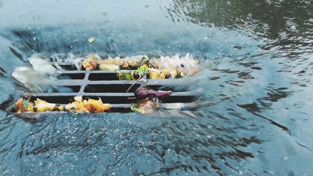 下雨时，水从道路排水沟流入雨水沟下水道收集器。主要渠道的排水网络。城市里的雨天。恶劣和危险的交通条件视频素材