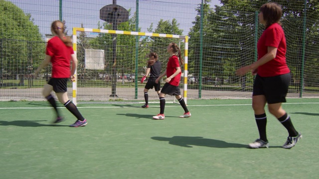 年轻女子在绿地上踢足球视频素材